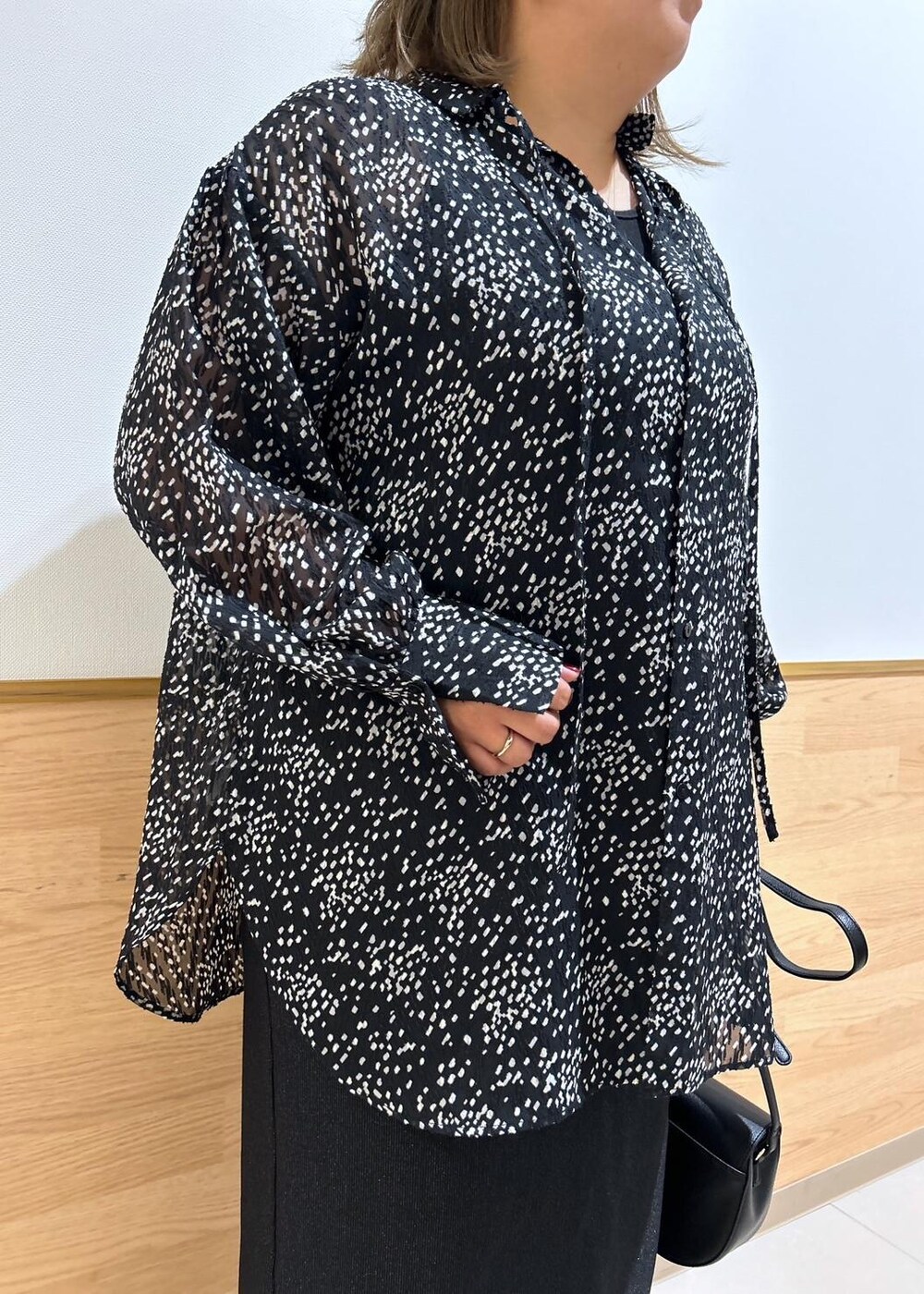 ブラック系のスカート、ブラック系のショルダーバッグ、ブラック系のシャツ/ブラウスを着用したレディースの秋コーディネートの5枚目の写真