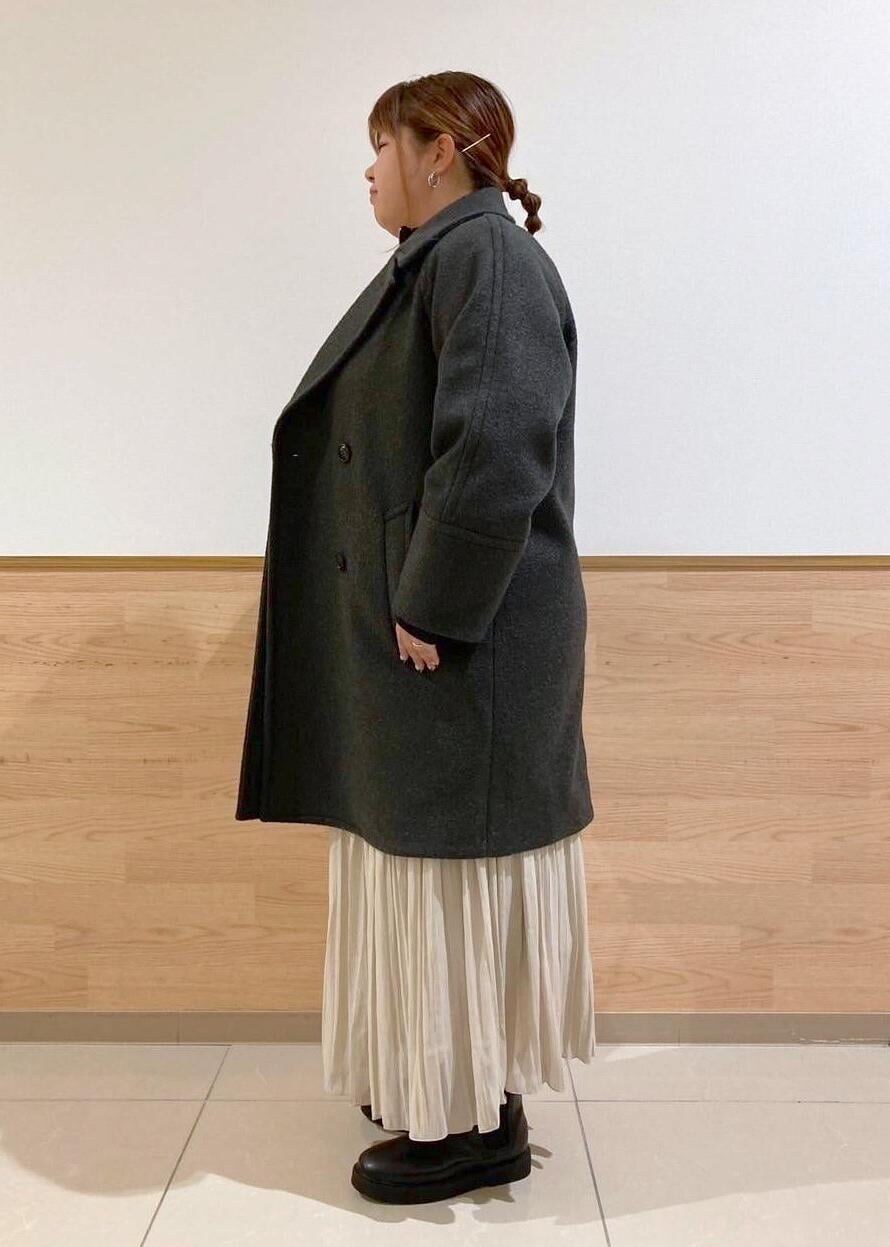 ベージュ系のスカート、ブラック系のブーツ、ブラック系のニット/セーターを着用したレディースの秋コーディネートの2枚目の写真