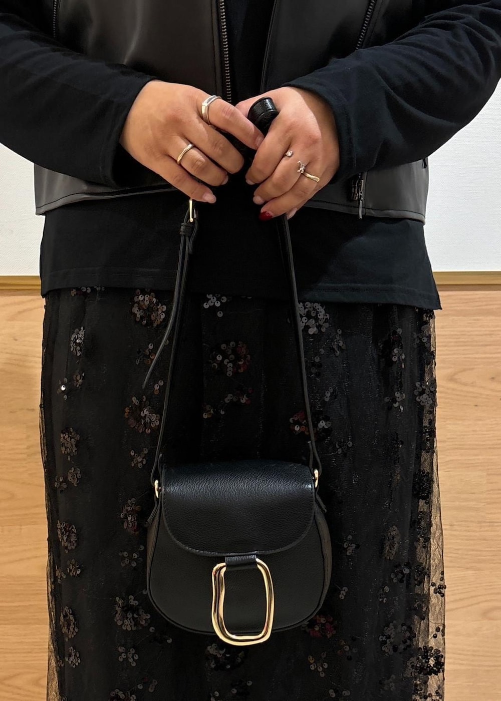 ブラック系のスカート、ブラック系のショルダーバッグ、ブラック系のライダースジャケットを着用したレディースの秋コーディネートの8枚目の写真