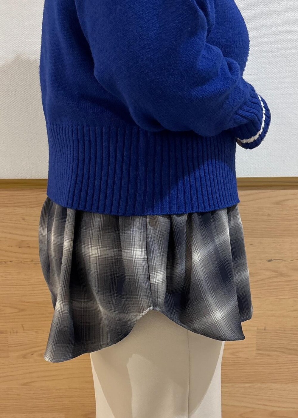 ベージュ系のスカート、ブルー系のニット/セーター、ブラック系のブーツを着用したレディースの冬コーディネートの6枚目の写真