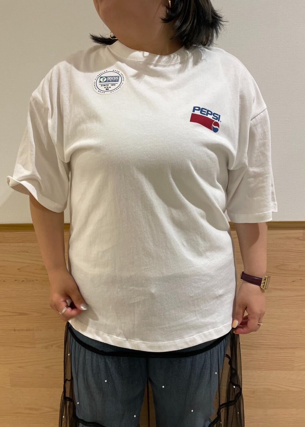 ブラック系のスカート、ブラック系のサンダル、ホワイト系のTシャツ/カットソーを着用したレディースの夏コーディネートの4枚目の写真