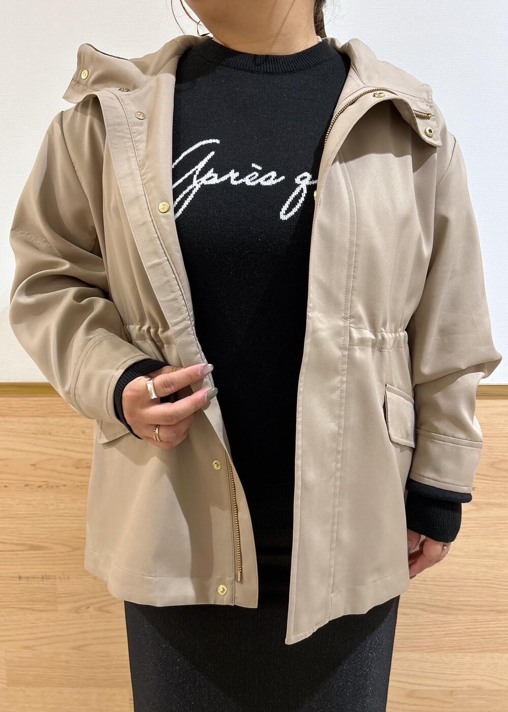 ブラック系のスカート、ブラウン系のマウンテンパーカー、ブラック系のブーツを着用したレディースの秋コーディネートの5枚目の写真