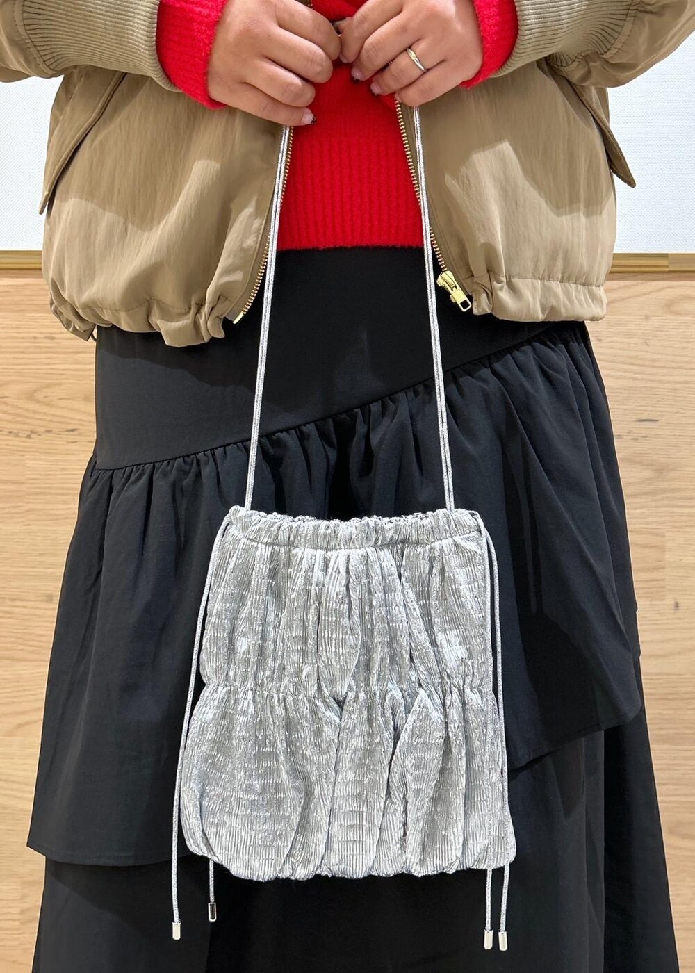 ブラック系のスカート、ブラック系のブーツ、シルバー系のショルダーバッグを着用したレディースの秋コーディネートの7枚目の写真