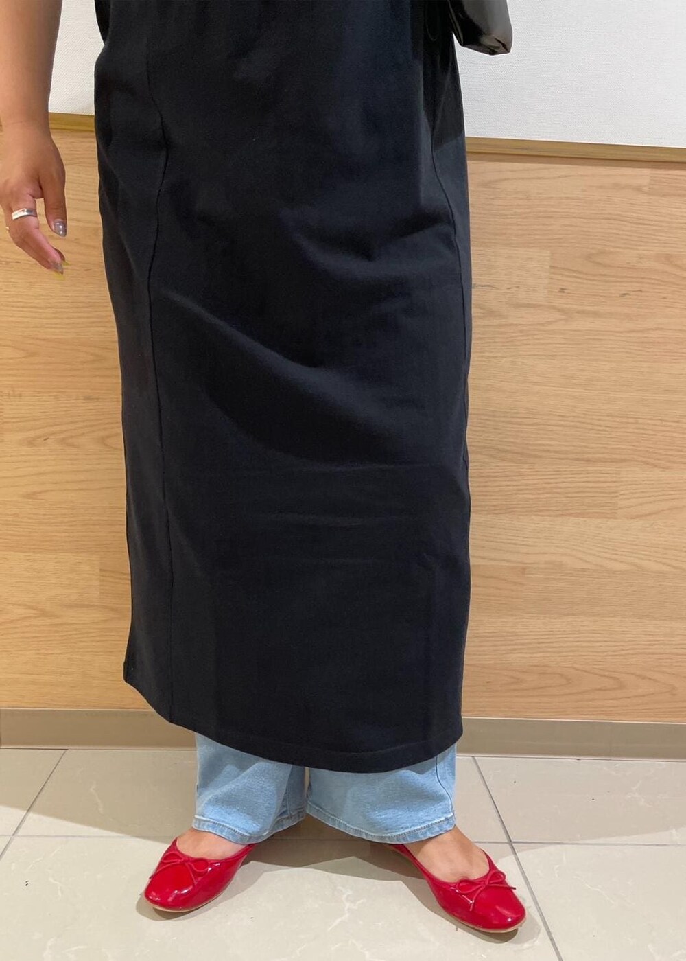 ブラック系のトートバッグ、ブルー系のデニムパンツ、レッド系のバレエシューズを着用したレディースの秋コーディネートの4枚目の写真