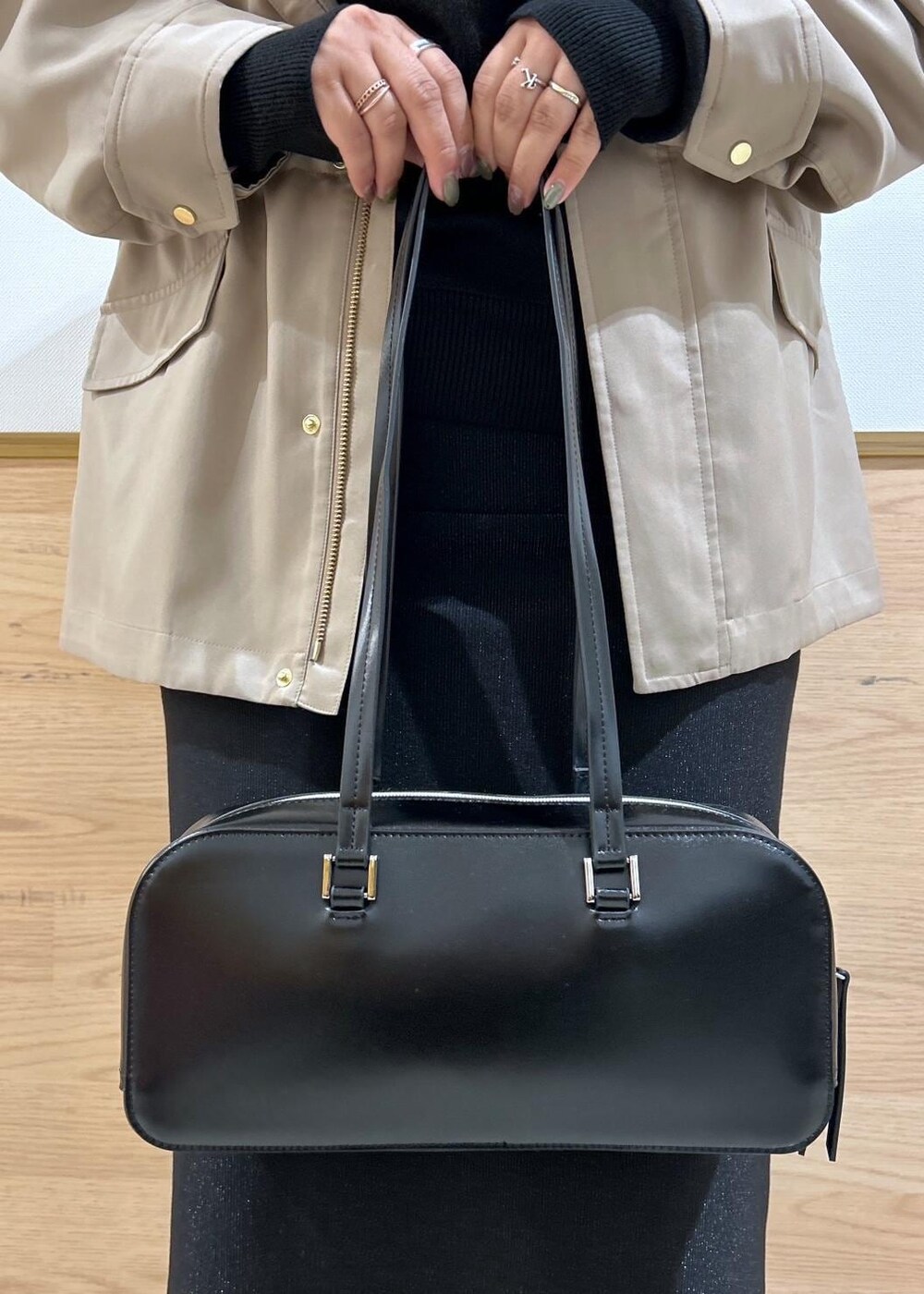 ブラック系のスカート、ブラウン系のマウンテンパーカー、ブラック系のブーツを着用したレディースの秋コーディネートの8枚目の写真