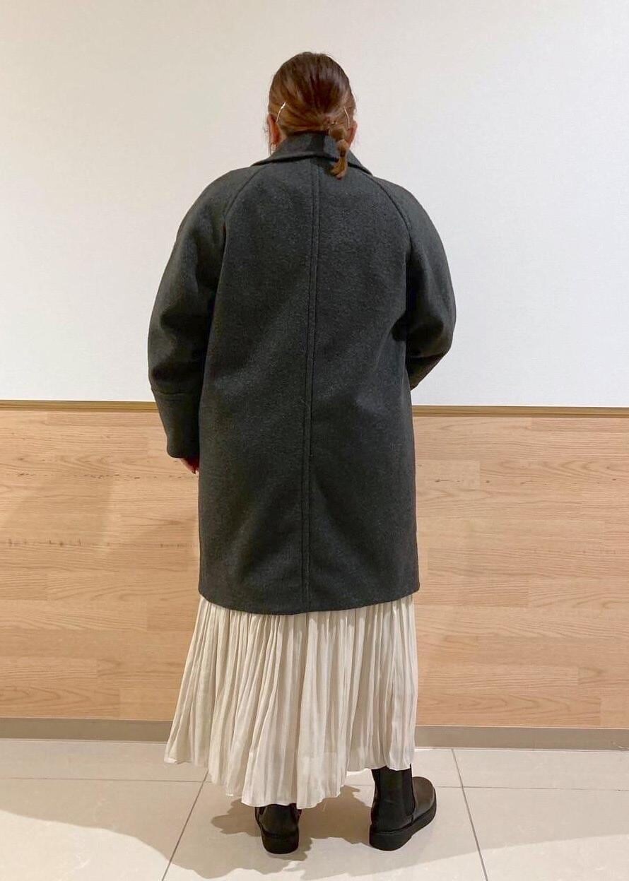 ベージュ系のスカート、ブラック系のブーツ、ブラック系のニット/セーターを着用したレディースの秋コーディネートの3枚目の写真