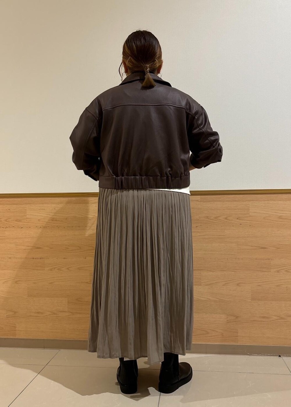 ホワイト系のTシャツ/カットソー、ブラック系のブーツ、ブラウン系のスカートを着用したレディースの秋コーディネートの3枚目の写真