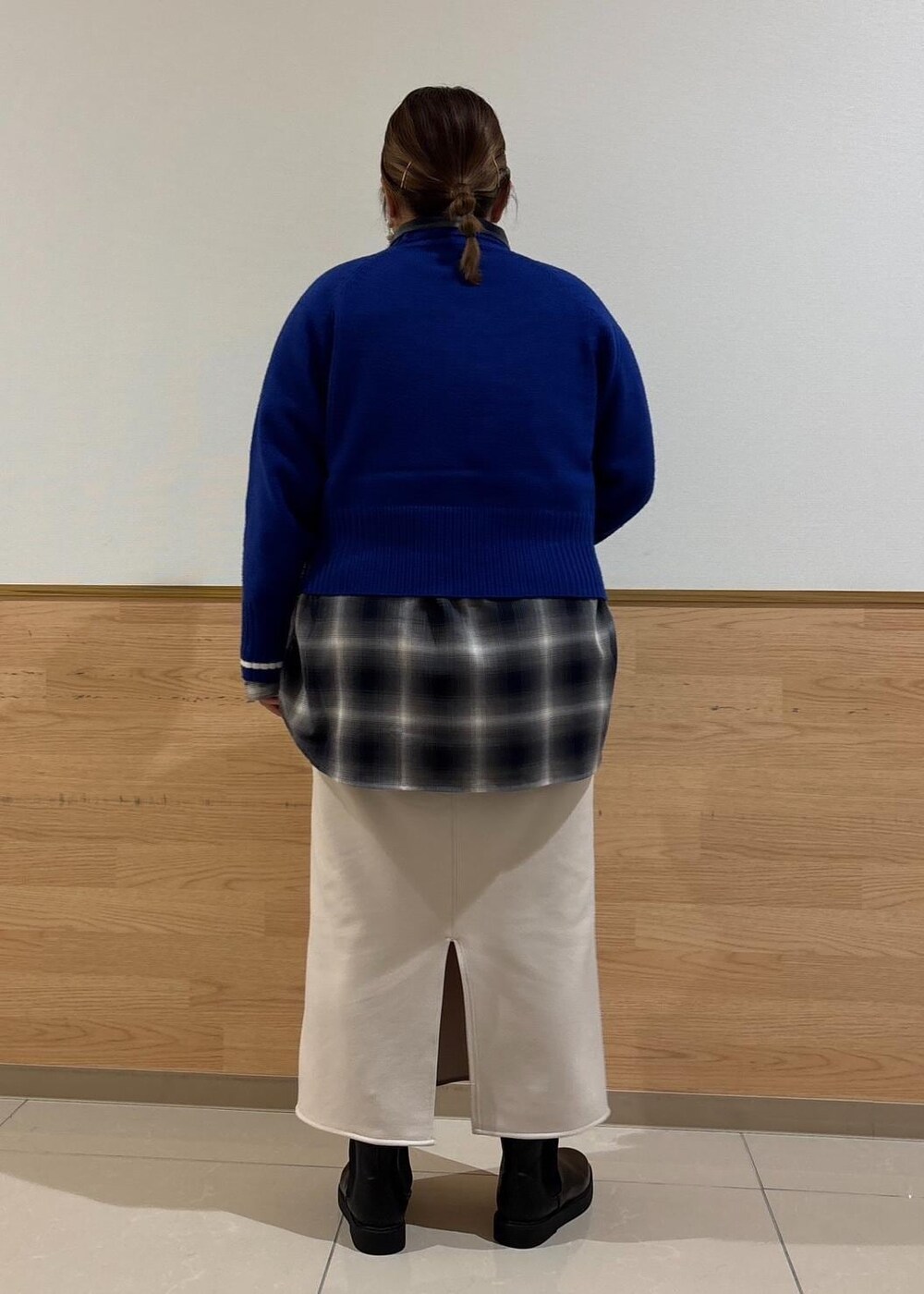 ベージュ系のスカート、ブルー系のニット/セーター、ブラック系のブーツを着用したレディースの冬コーディネートの3枚目の写真