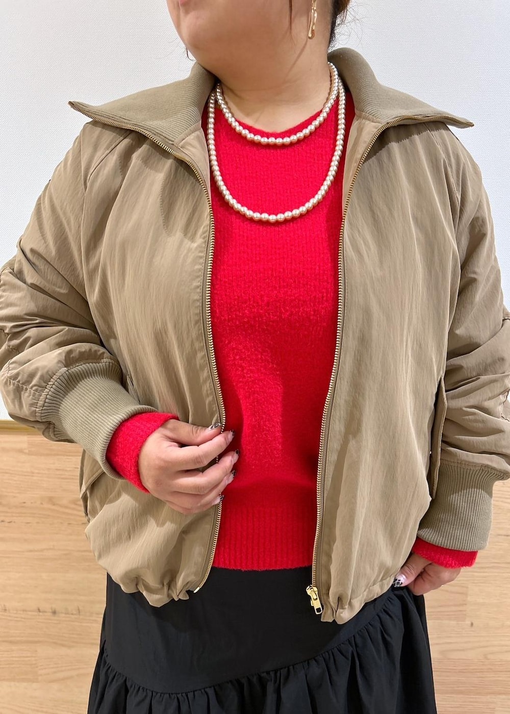 ブラック系のスカート、ブラック系のブーツ、シルバー系のショルダーバッグを着用したレディースの秋コーディネートの4枚目の写真