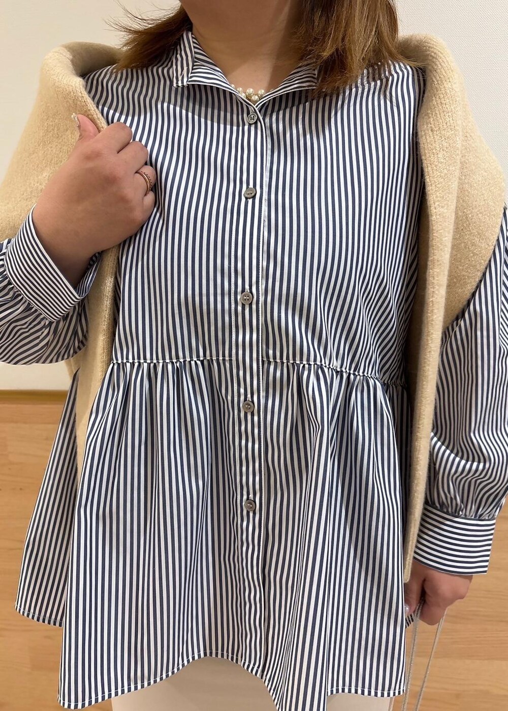 ベージュ系のスカート、ベージュ系のニット/セーター、シルバー系のショルダーバッグを着用したレディースの冬コーディネートの4枚目の写真