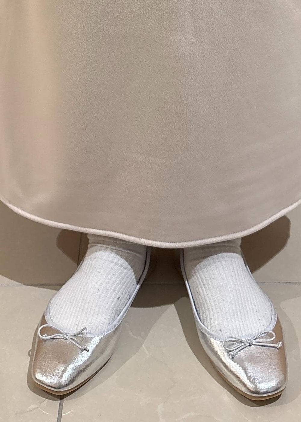 ベージュ系のスカート、ベージュ系のTシャツ/カットソー、ブルー系のベストを着用したレディースの冬コーディネートの8枚目の写真