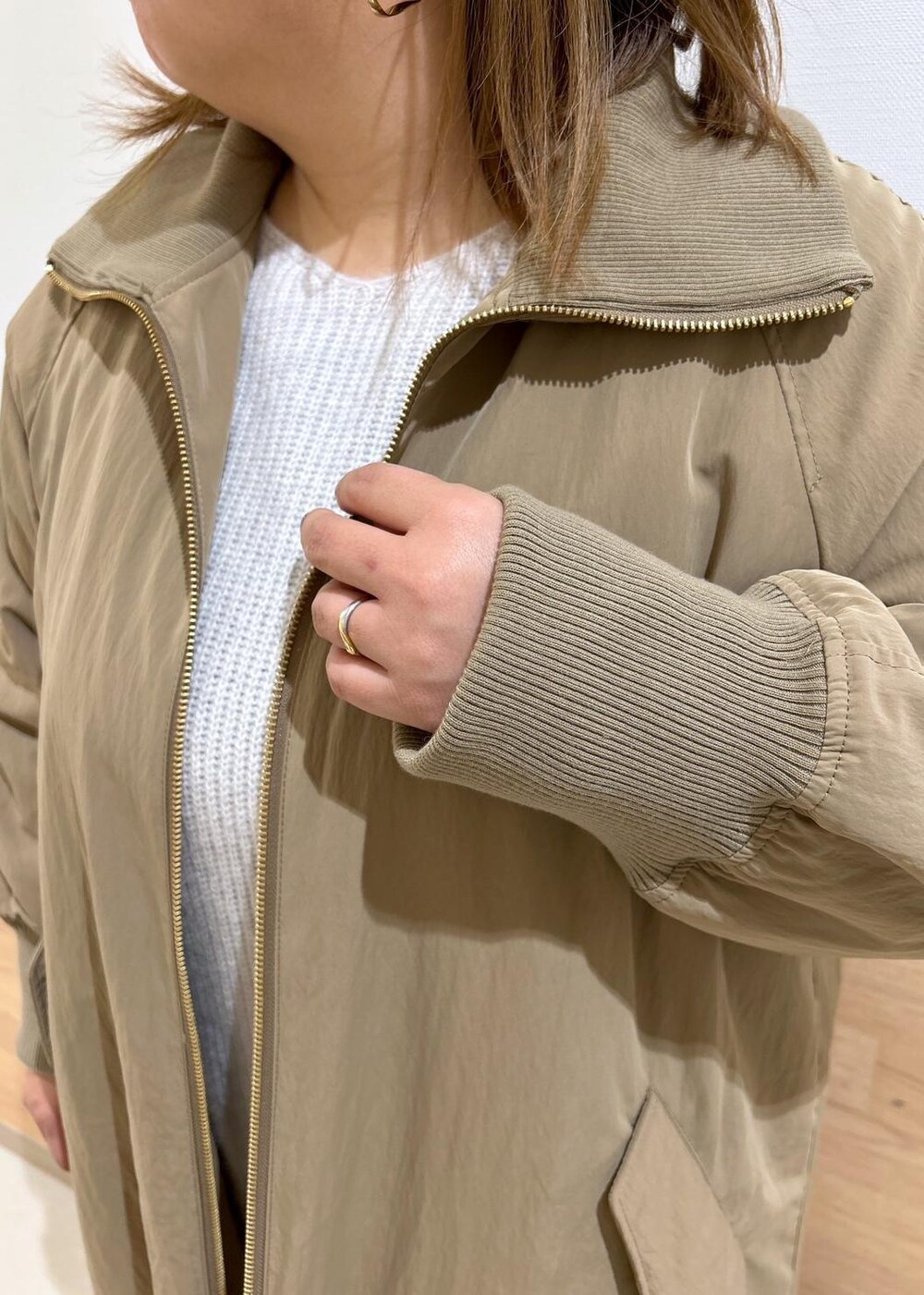 グレー系のワンピース、ブラック系のショルダーバッグ、ベージュ系のその他アウターを着用したレディースの冬コーディネートの5枚目の写真