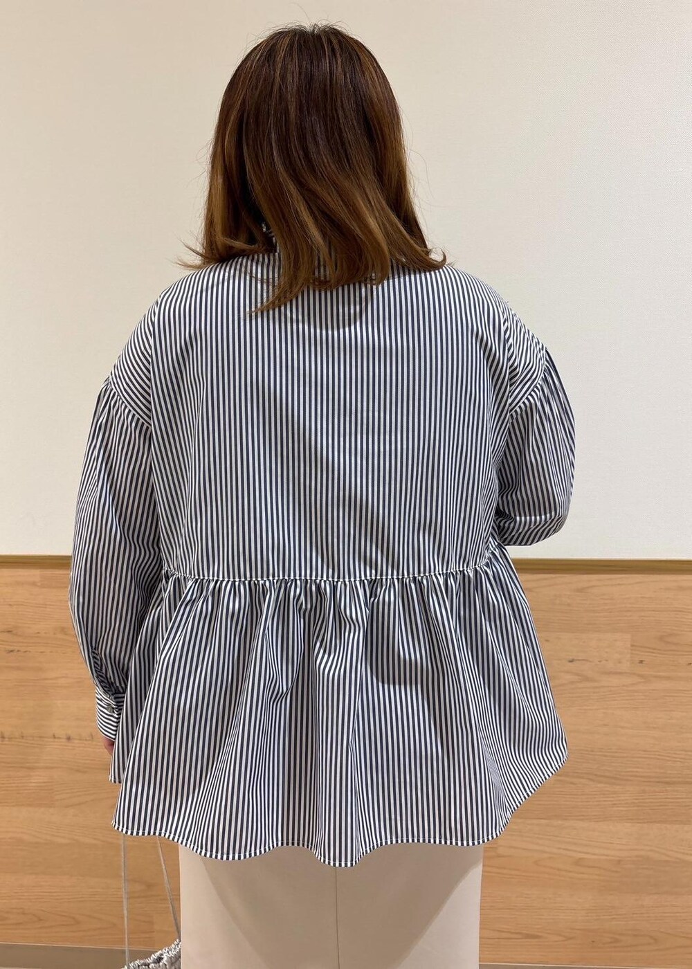 ベージュ系のスカート、ベージュ系のニット/セーター、シルバー系のショルダーバッグを着用したレディースの冬コーディネートの8枚目の写真