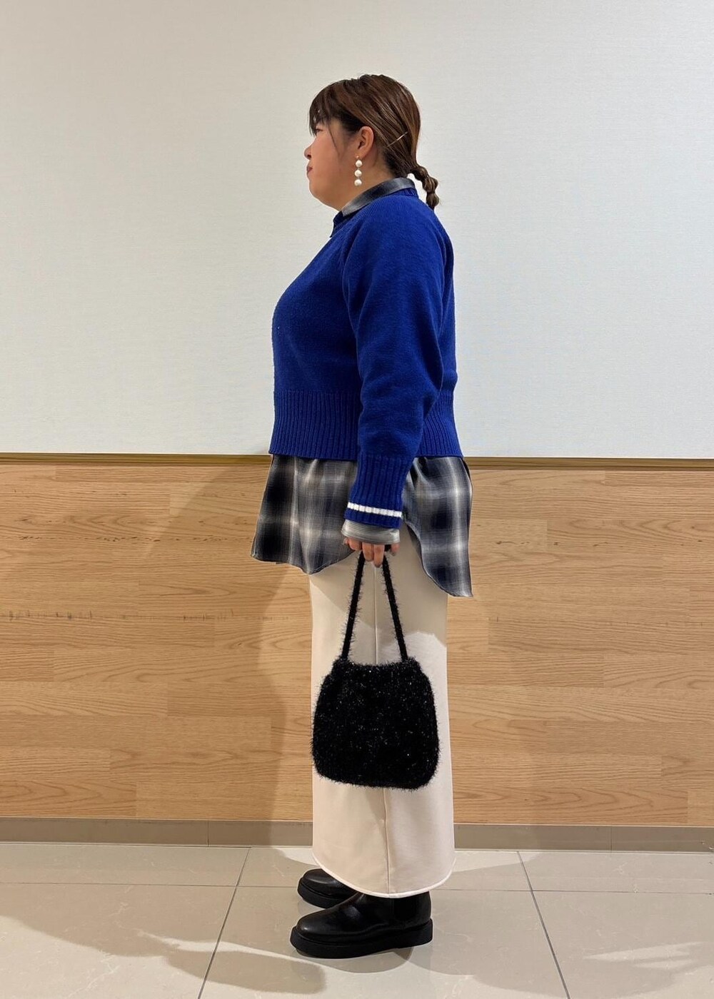 ベージュ系のスカート、ブルー系のニット/セーター、ブラック系のブーツを着用したレディースの冬コーディネートの2枚目の写真