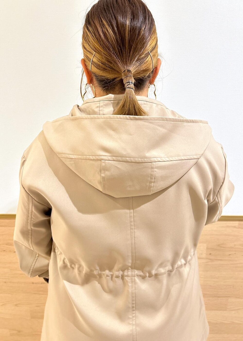 ブラック系のスカート、ブラウン系のマウンテンパーカー、ブラック系のブーツを着用したレディースの秋コーディネートの4枚目の写真