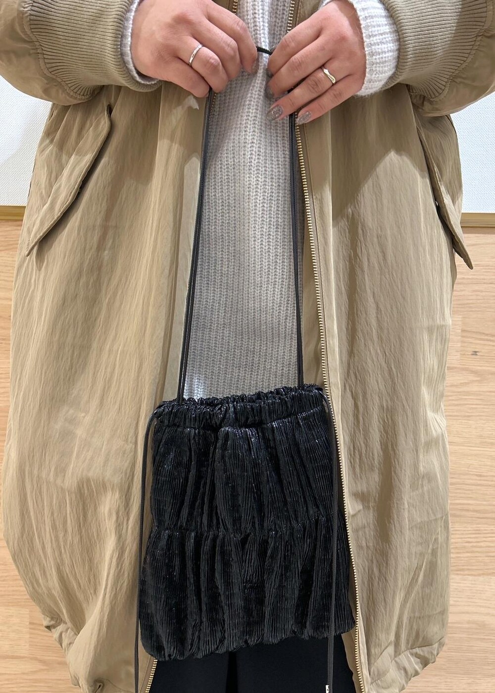 グレー系のワンピース、ブラック系のショルダーバッグ、ベージュ系のその他アウターを着用したレディースの冬コーディネートの9枚目の写真