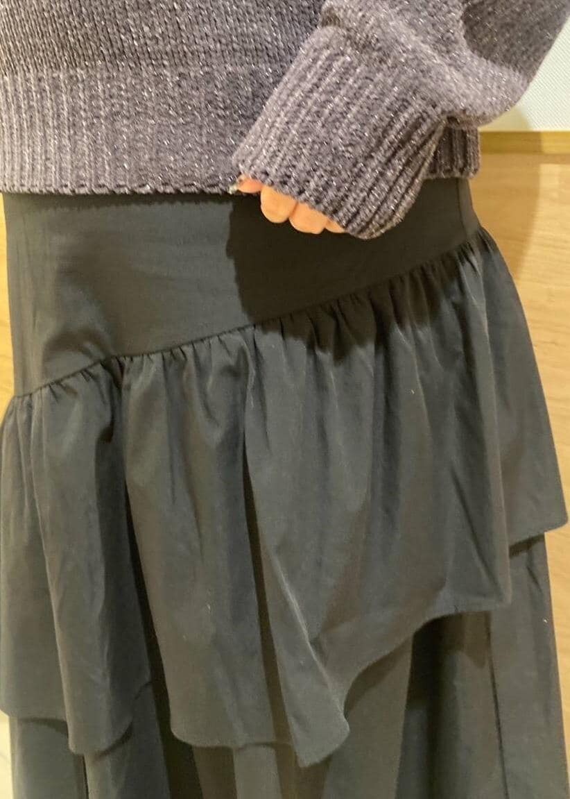 ブラック系のスカート、ブラック系のブーツ、グレー系のショルダーバッグを着用したレディースの冬コーディネートの6枚目の写真