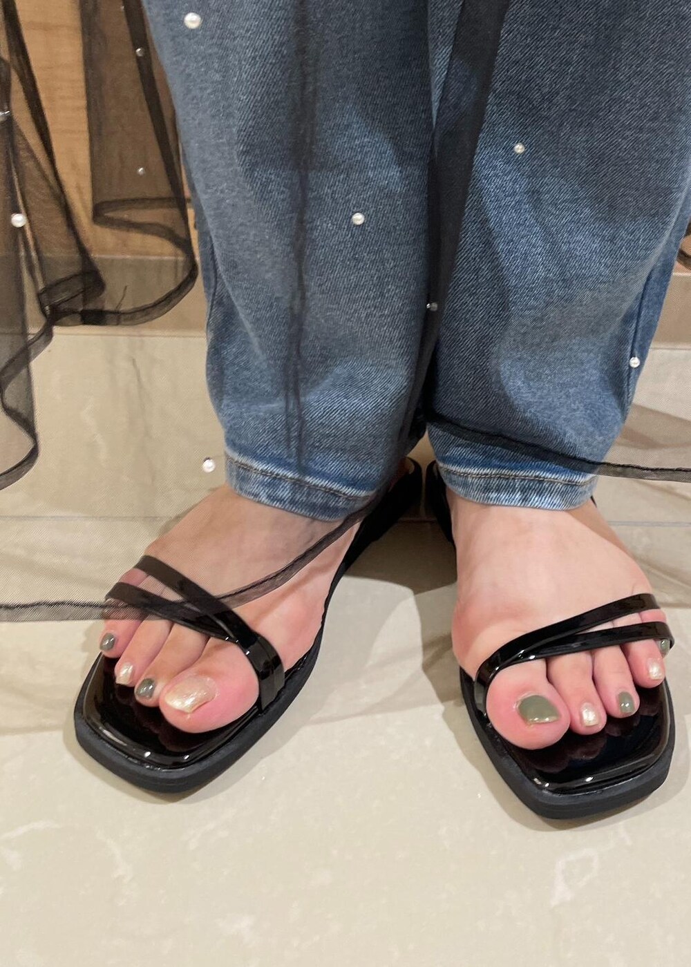 ブラック系のスカート、ブラック系のサンダル、ホワイト系のTシャツ/カットソーを着用したレディースの夏コーディネートの10枚目の写真