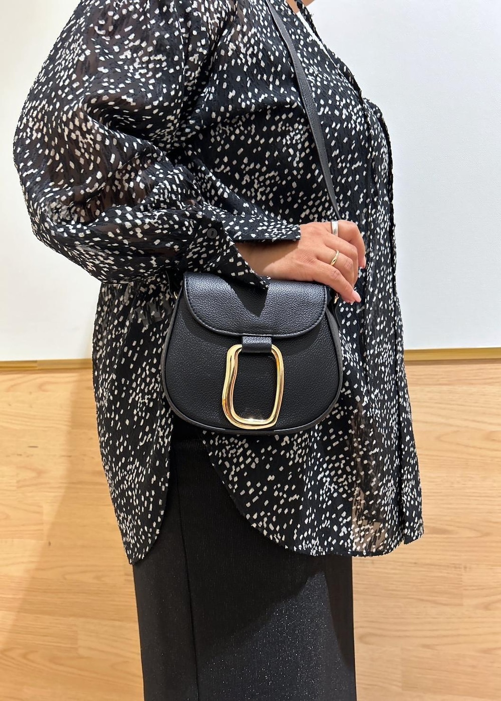 ブラック系のスカート、ブラック系のショルダーバッグ、ブラック系のシャツ/ブラウスを着用したレディースの秋コーディネートの7枚目の写真