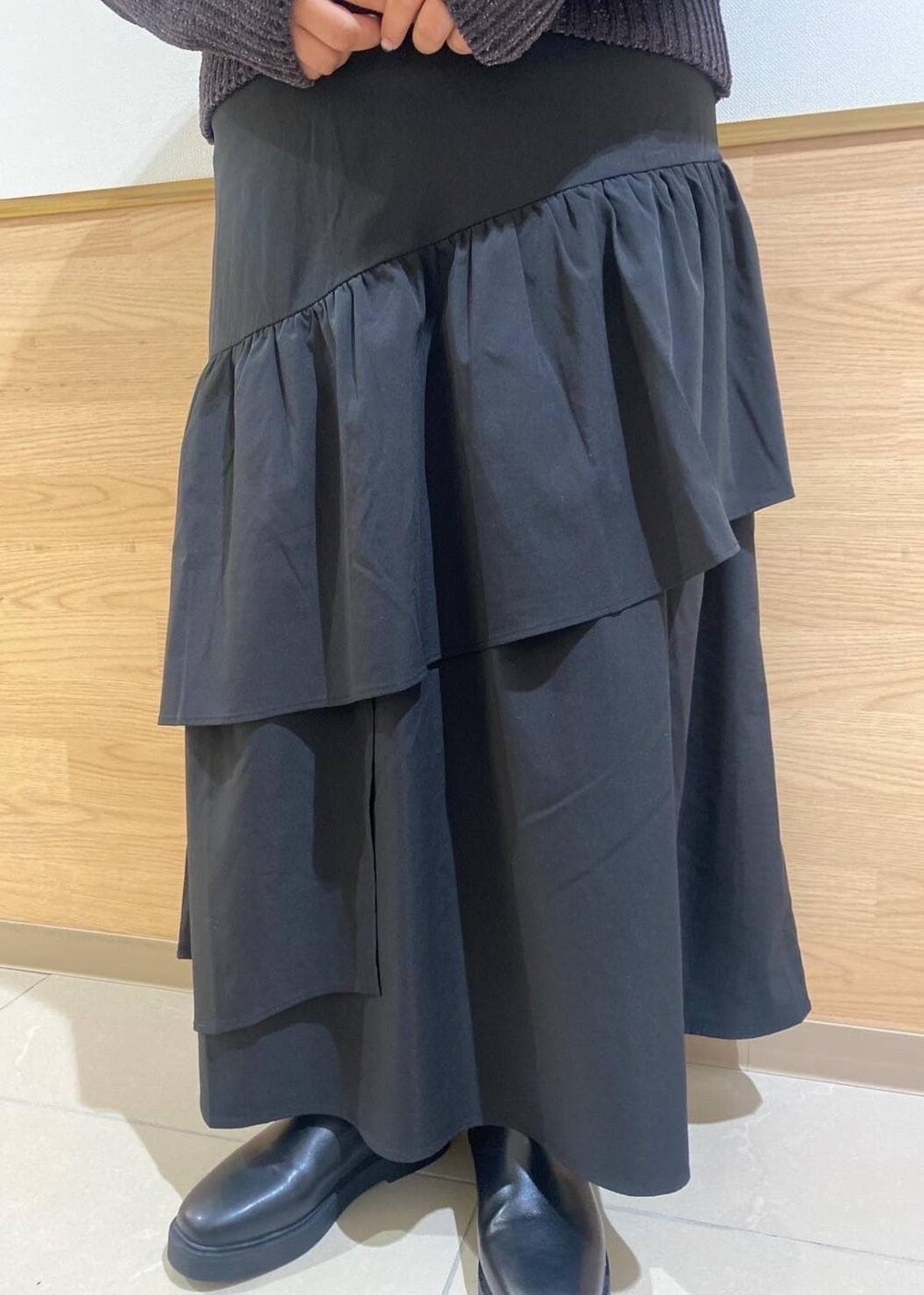 ブラック系のスカート、ブラック系のブーツ、グレー系のショルダーバッグを着用したレディースの冬コーディネートの7枚目の写真