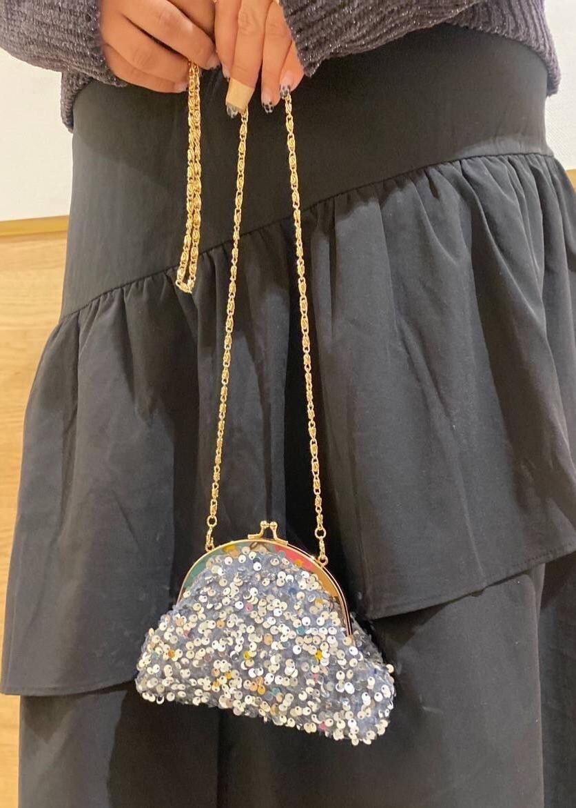 ブラック系のスカート、ブラック系のブーツ、グレー系のショルダーバッグを着用したレディースの冬コーディネートの8枚目の写真