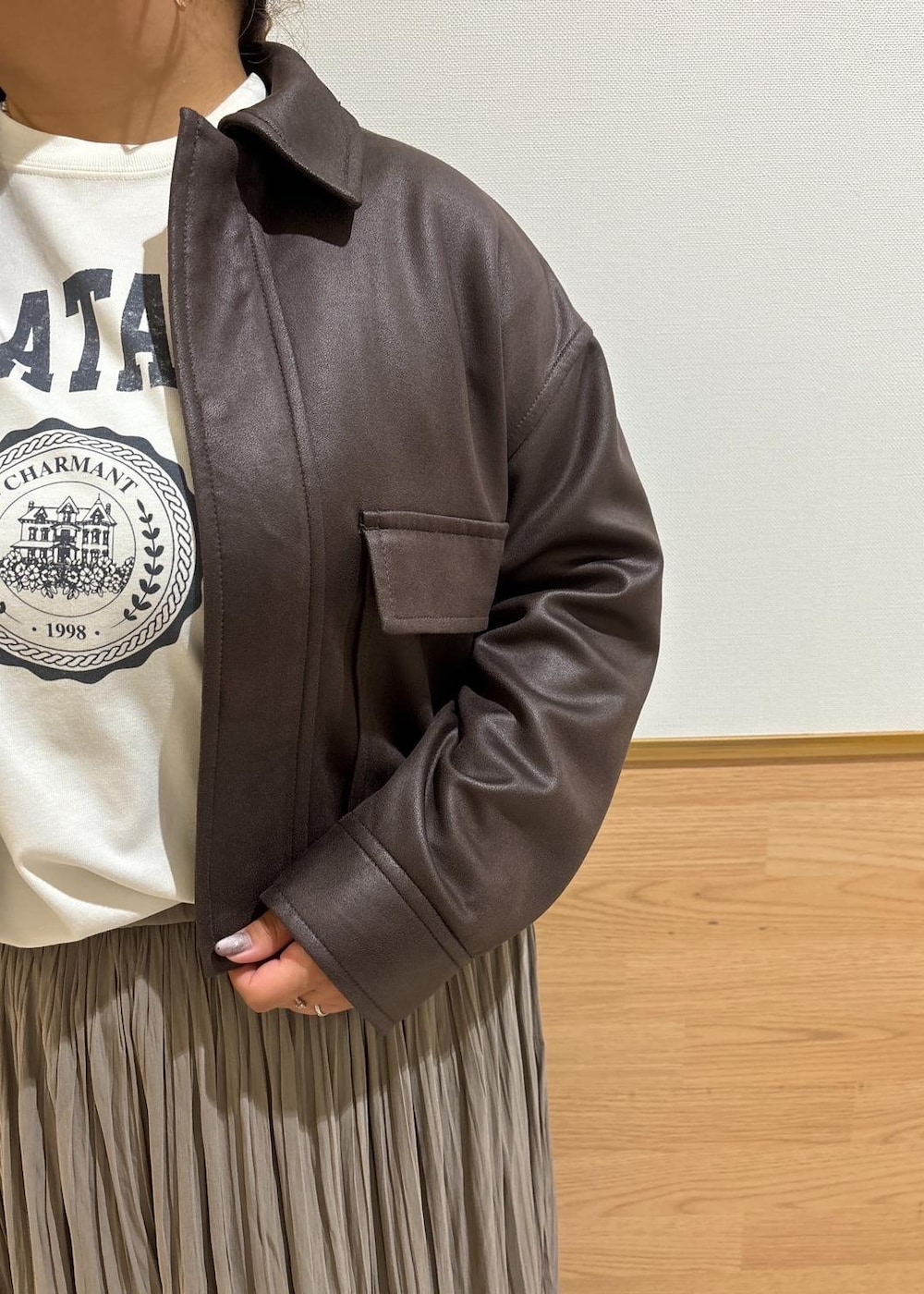 ホワイト系のTシャツ/カットソー、ブラック系のブーツ、ブラウン系のスカートを着用したレディースの秋コーディネートの5枚目の写真