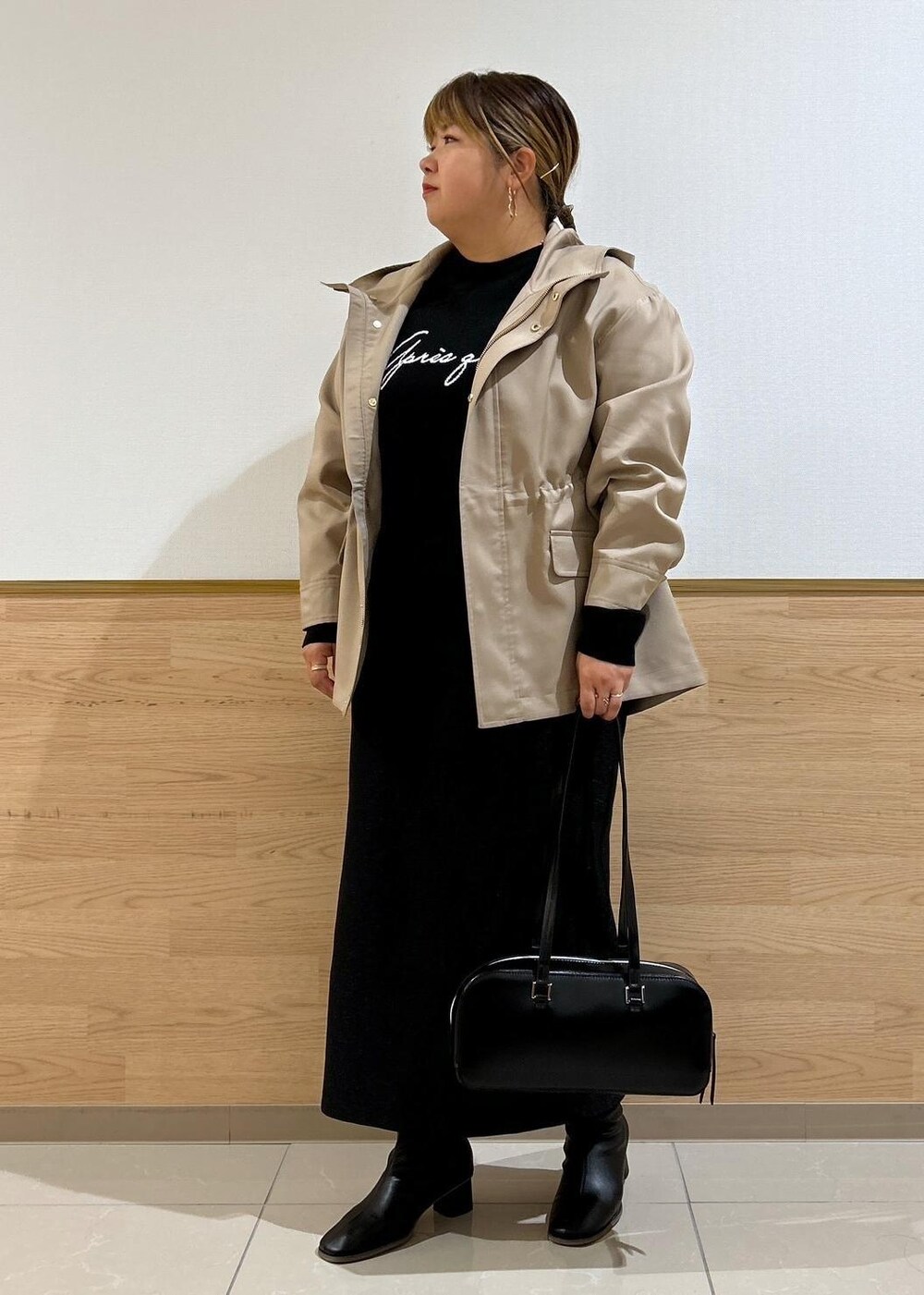 ブラック系のスカート、ブラウン系のマウンテンパーカー、ブラック系のブーツを着用したレディースの秋コーディネートの10枚目の写真