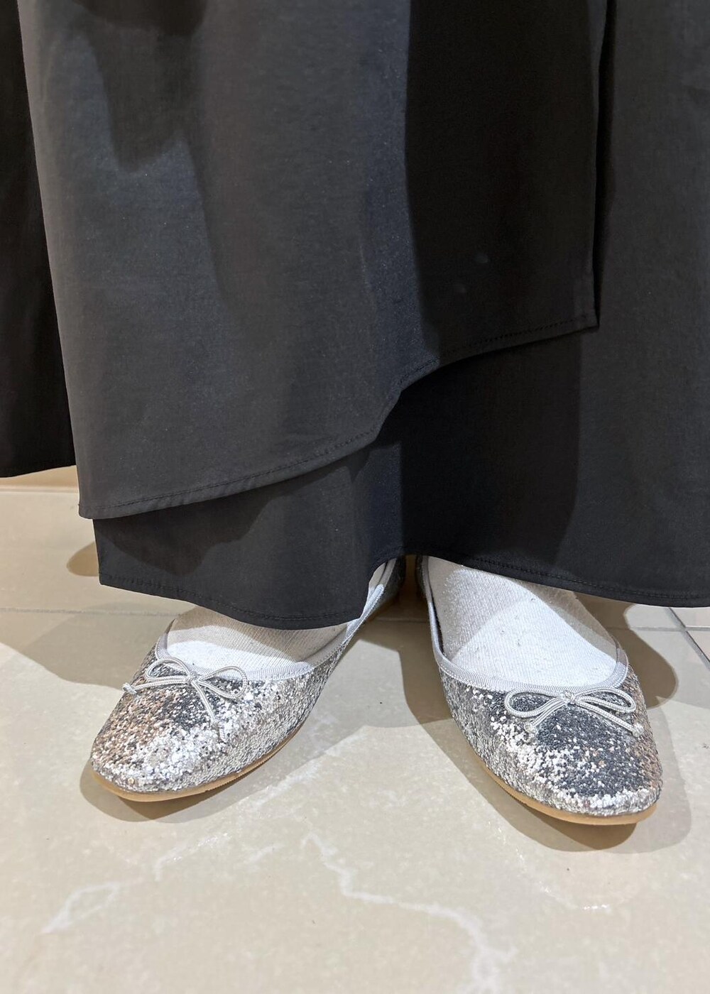 シルバー系のバレエシューズ、ブラック系のスカート、ブラウン系のニット/セーターを着用したレディースの秋コーディネートの9枚目の写真