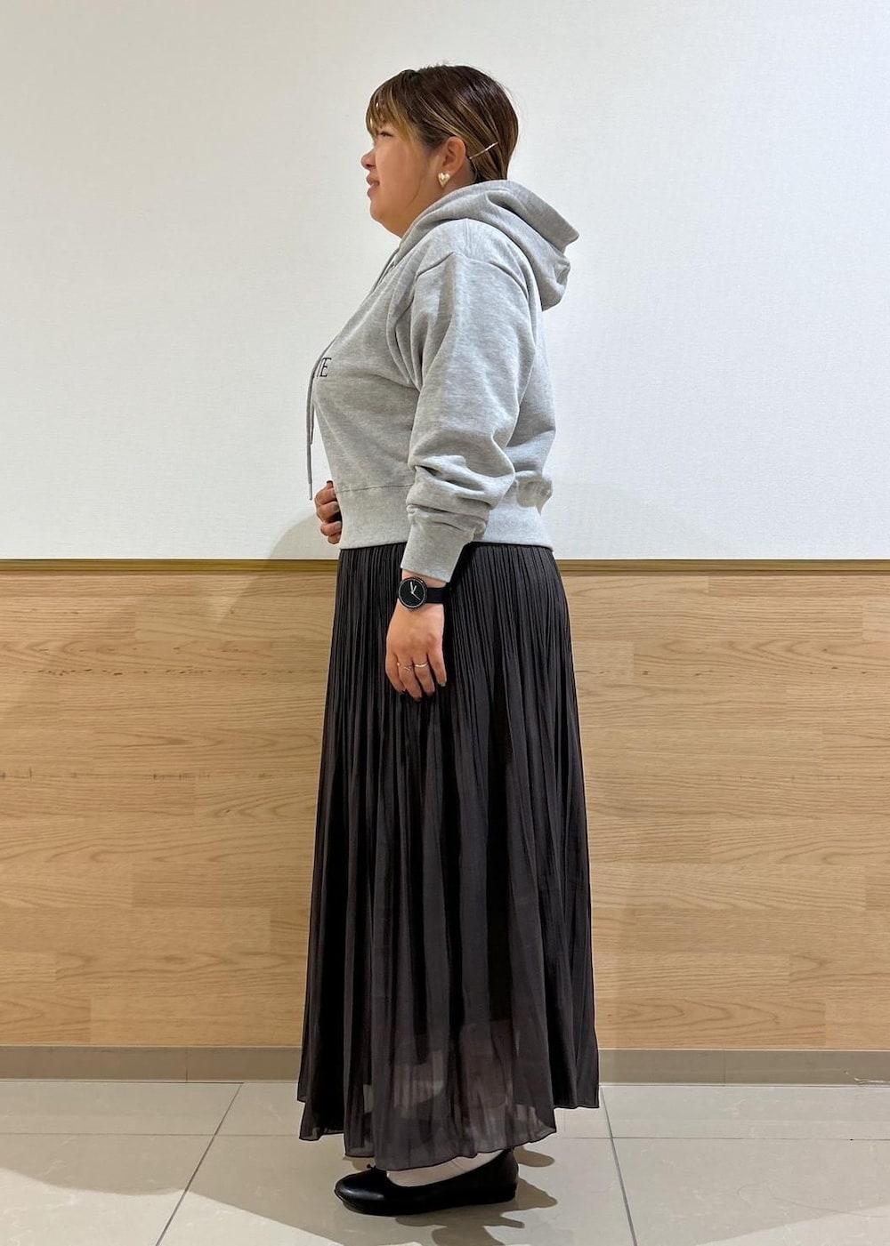 ブルー系のショルダーバッグ、ブラウン系のスカート、グレー系のパーカーを着用したレディースの秋コーディネートの2枚目の写真