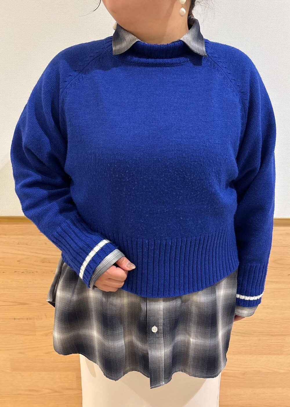 ベージュ系のスカート、ブルー系のニット/セーター、ブラック系のブーツを着用したレディースの冬コーディネートの4枚目の写真