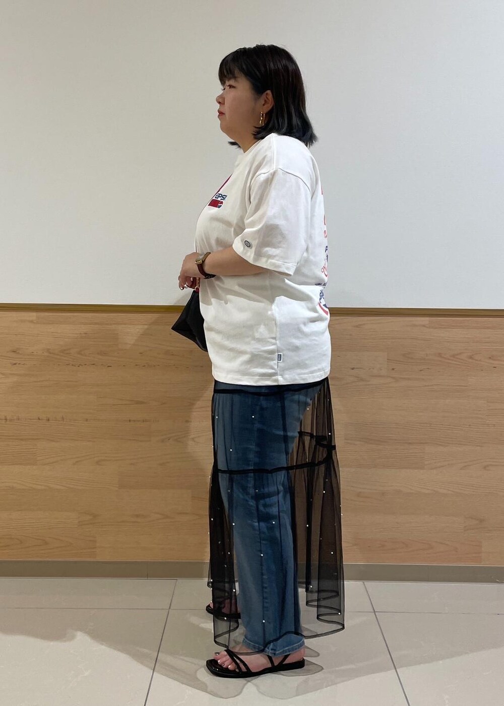 ブラック系のスカート、ブラック系のサンダル、ホワイト系のTシャツ/カットソーを着用したレディースの夏コーディネートの2枚目の写真