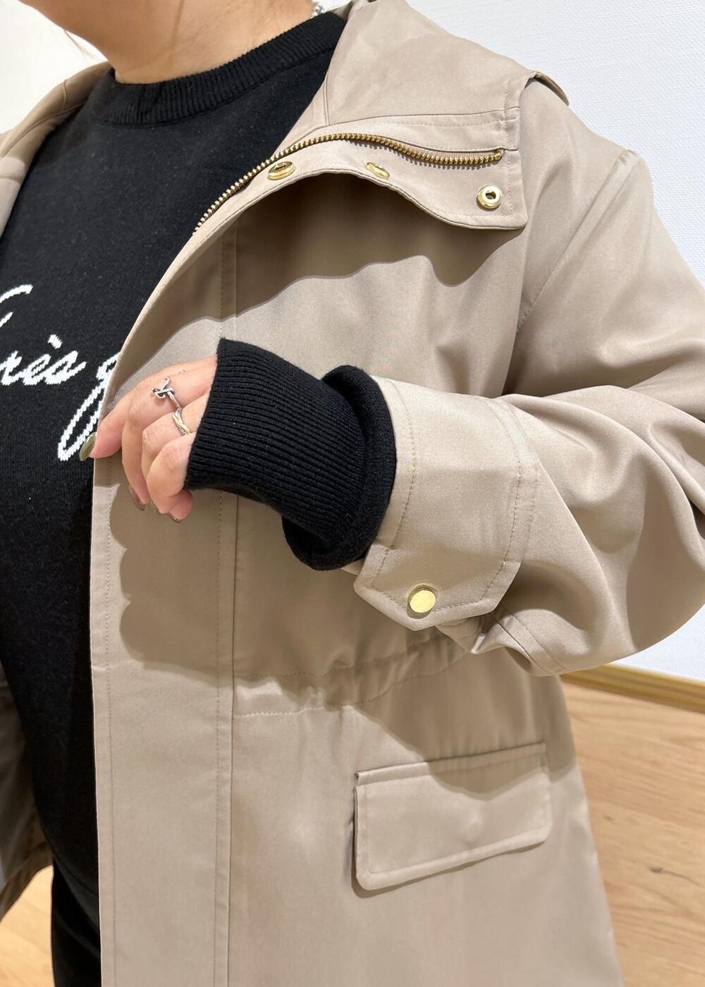 ブラック系のスカート、ブラウン系のマウンテンパーカー、ブラック系のブーツを着用したレディースの秋コーディネートの6枚目の写真