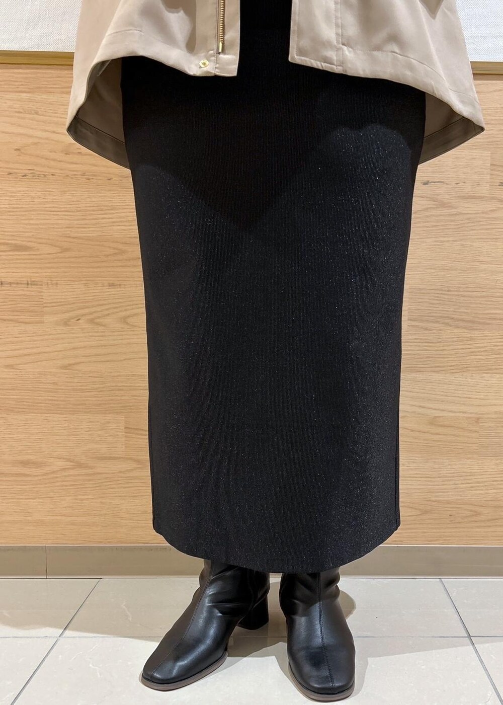 ブラック系のスカート、ブラウン系のマウンテンパーカー、ブラック系のブーツを着用したレディースの秋コーディネートの7枚目の写真