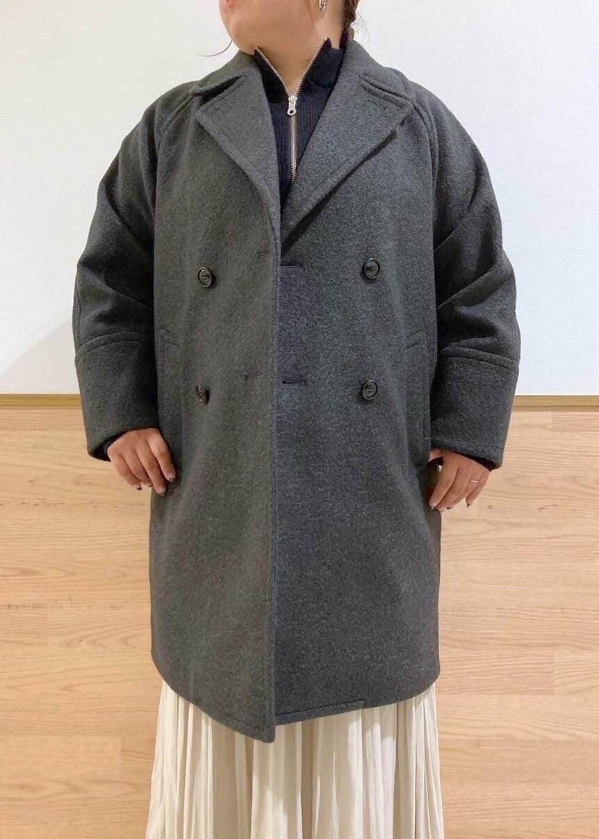 ベージュ系のスカート、ブラック系のブーツ、ブラック系のニット/セーターを着用したレディースの秋コーディネートの4枚目の写真