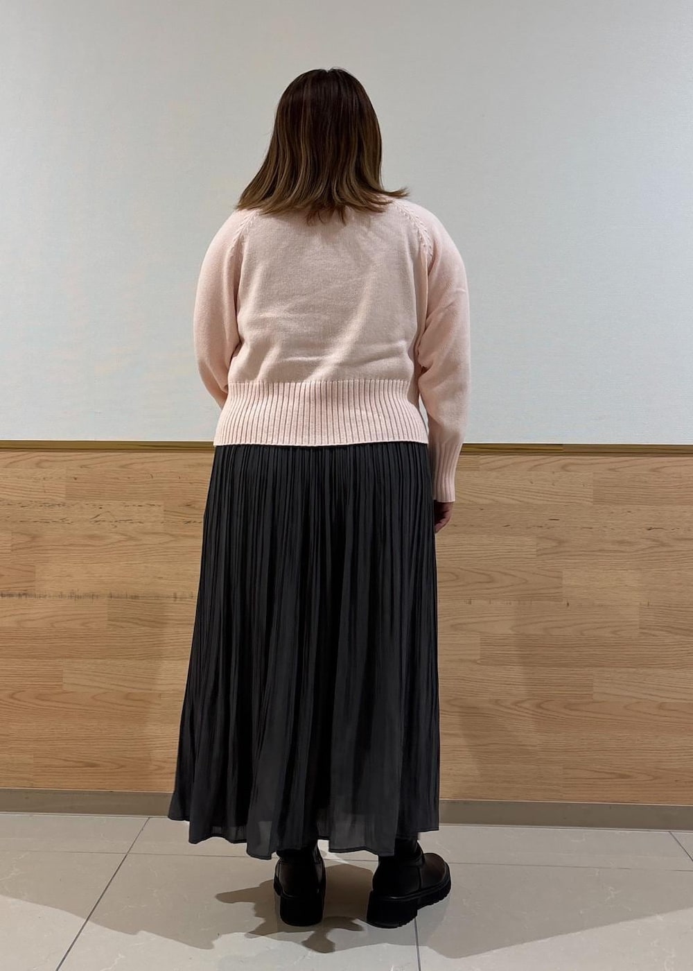 シルバー系のトートバッグ、グレー系のスカート、ピンク系のニット/セーターを着用したレディースの冬コーディネートの3枚目の写真