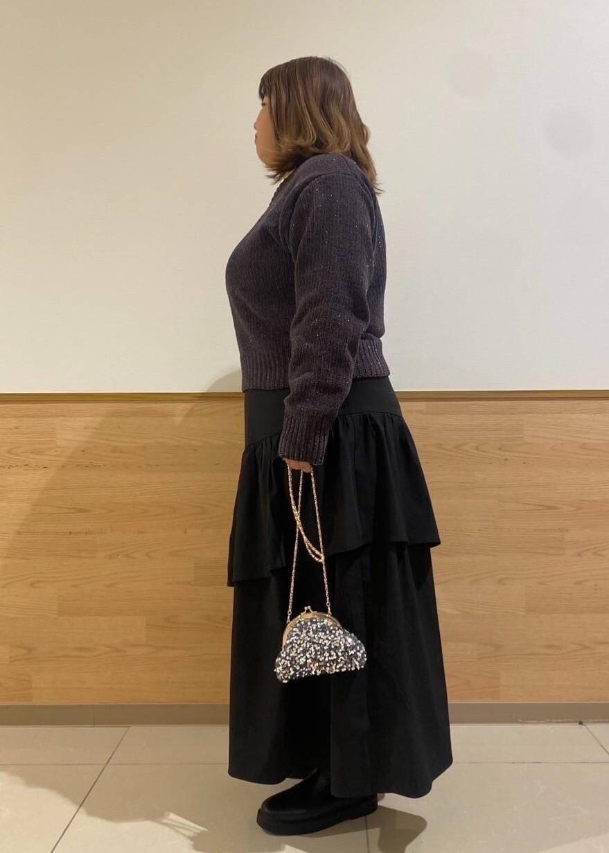 ブラック系のスカート、ブラック系のブーツ、グレー系のショルダーバッグを着用したレディースの冬コーディネートの2枚目の写真