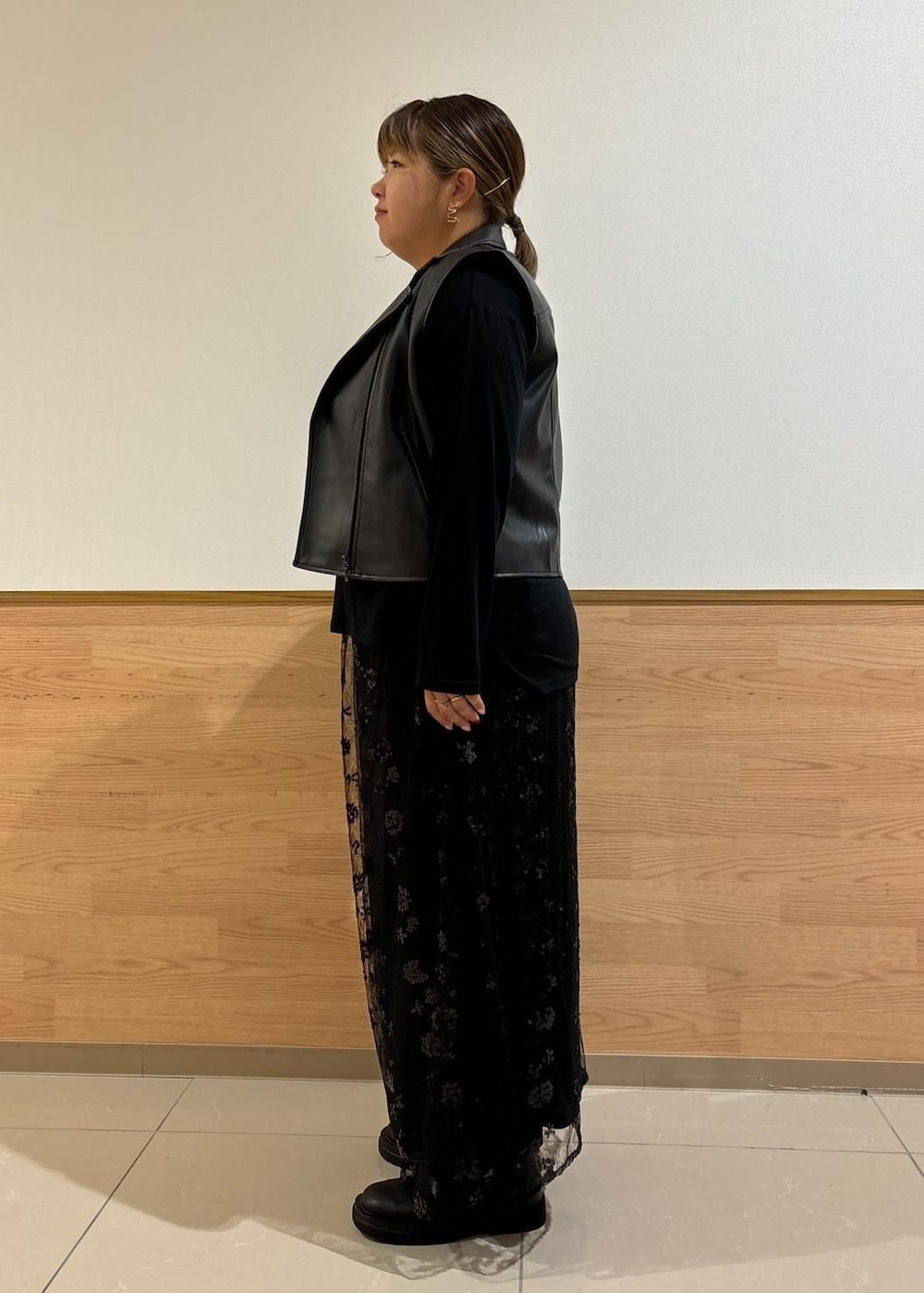 ブラック系のスカート、ブラック系のショルダーバッグ、ブラック系のライダースジャケットを着用したレディースの秋コーディネートの2枚目の写真