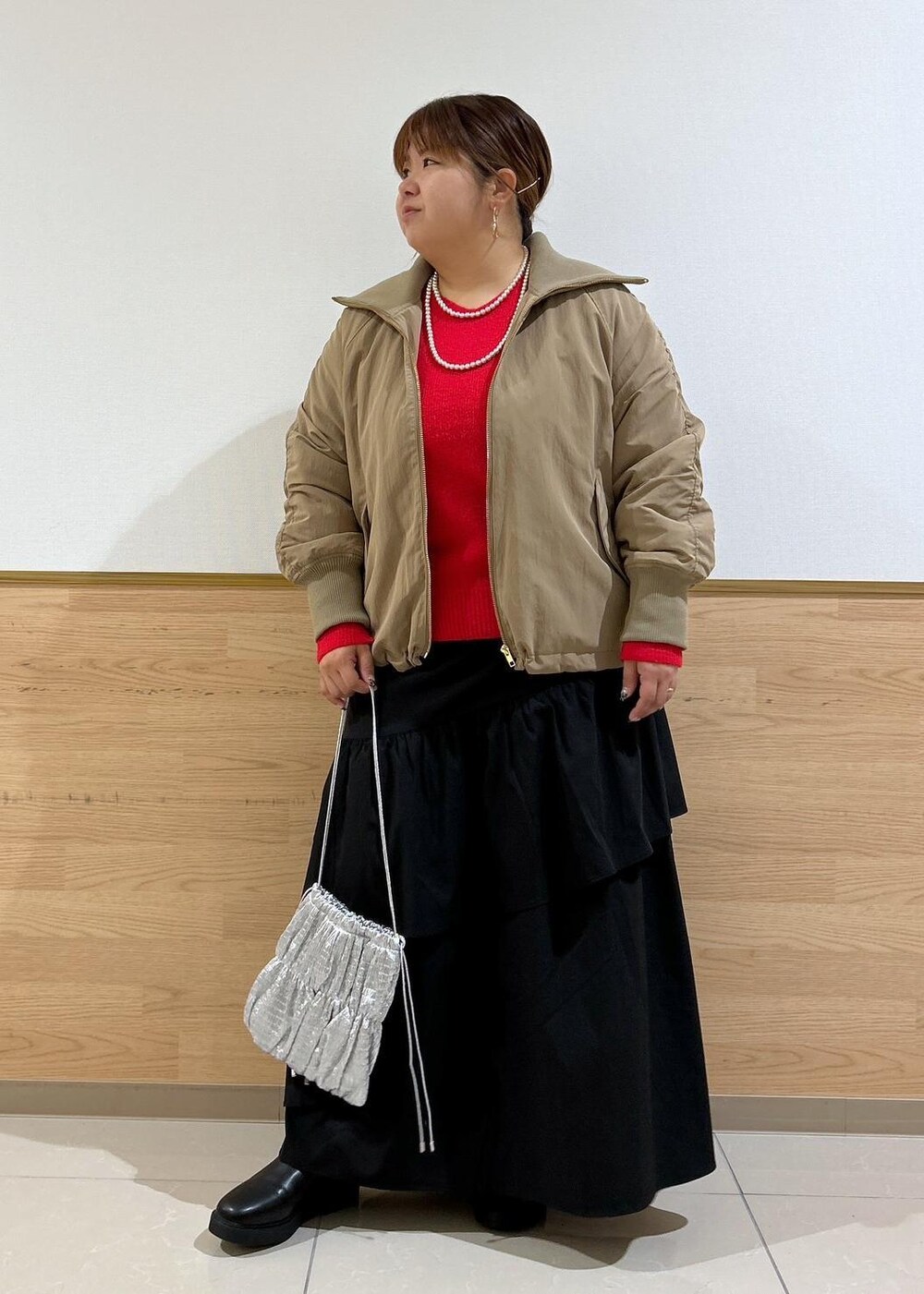 ブラック系のスカート、ブラック系のブーツ、シルバー系のショルダーバッグを着用したレディースの秋コーディネートの9枚目の写真