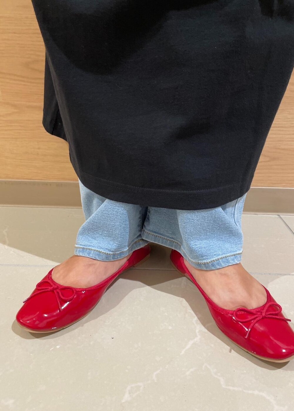 ブラック系のトートバッグ、ブルー系のデニムパンツ、レッド系のバレエシューズを着用したレディースの秋コーディネートの9枚目の写真