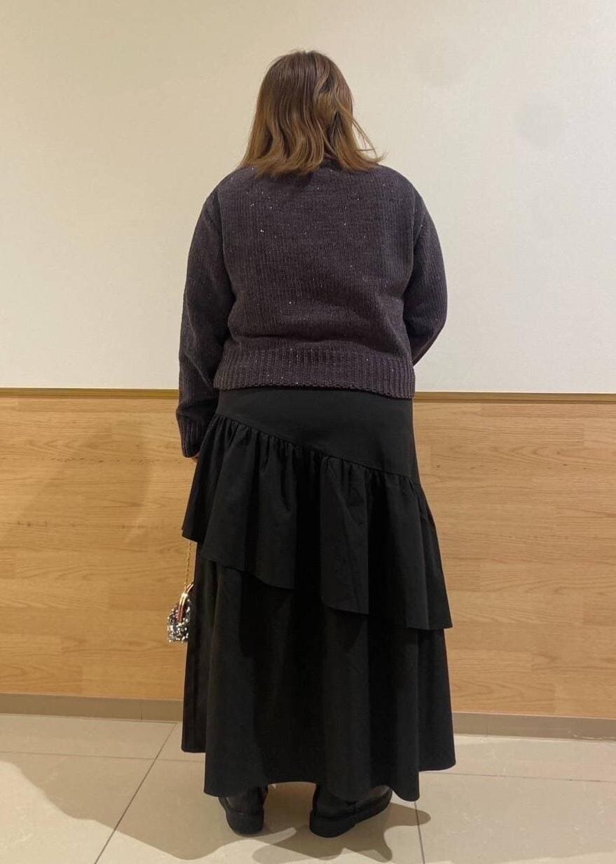 ブラック系のスカート、ブラック系のブーツ、グレー系のショルダーバッグを着用したレディースの冬コーディネートの3枚目の写真