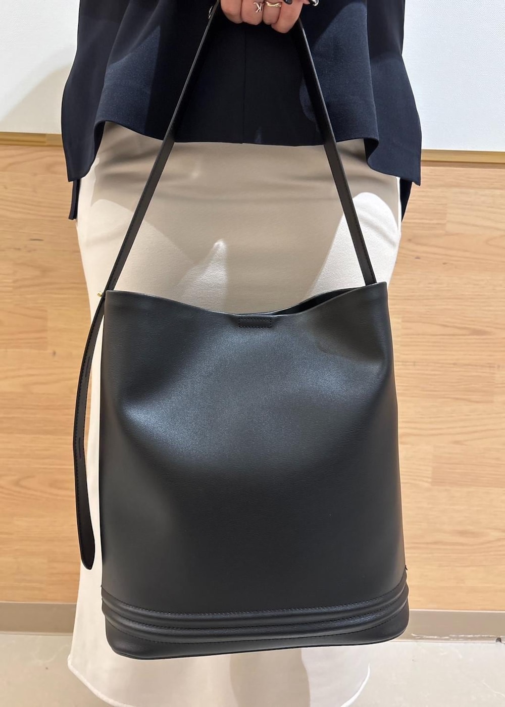 ベージュ系のスカート、ベージュ系のTシャツ/カットソー、ブルー系のベストを着用したレディースの冬コーディネートの7枚目の写真