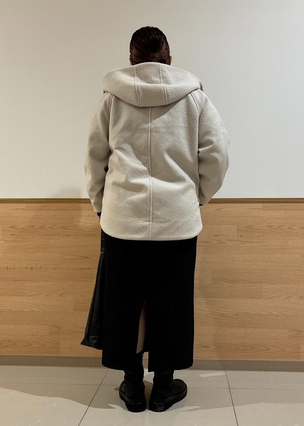 ブラック系のスカート、ブラック系のトートバッグ、ブルー系のニット/セーターを着用したレディースの秋コーディネートの3枚目の写真