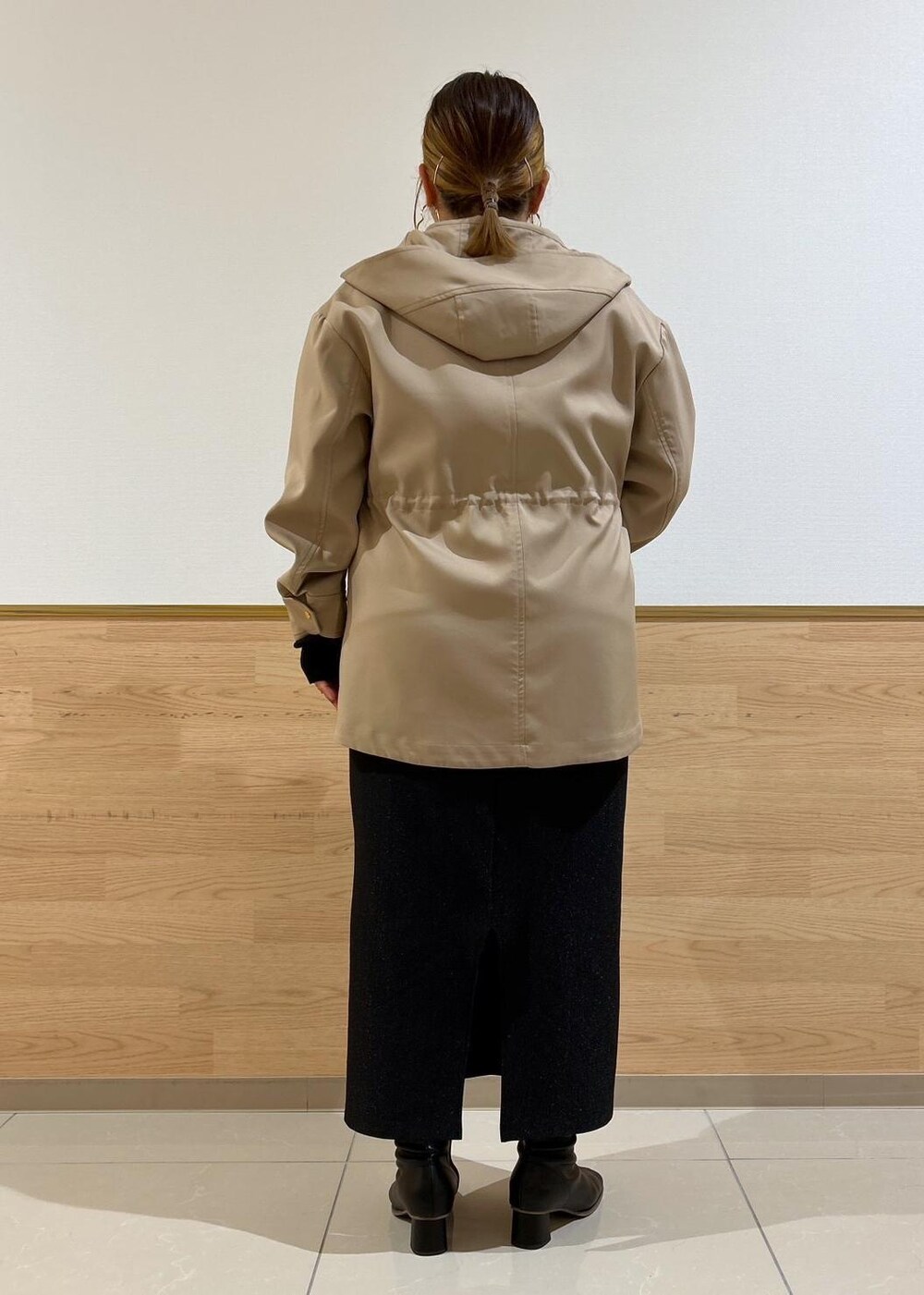 ブラック系のスカート、ブラウン系のマウンテンパーカー、ブラック系のブーツを着用したレディースの秋コーディネートの3枚目の写真