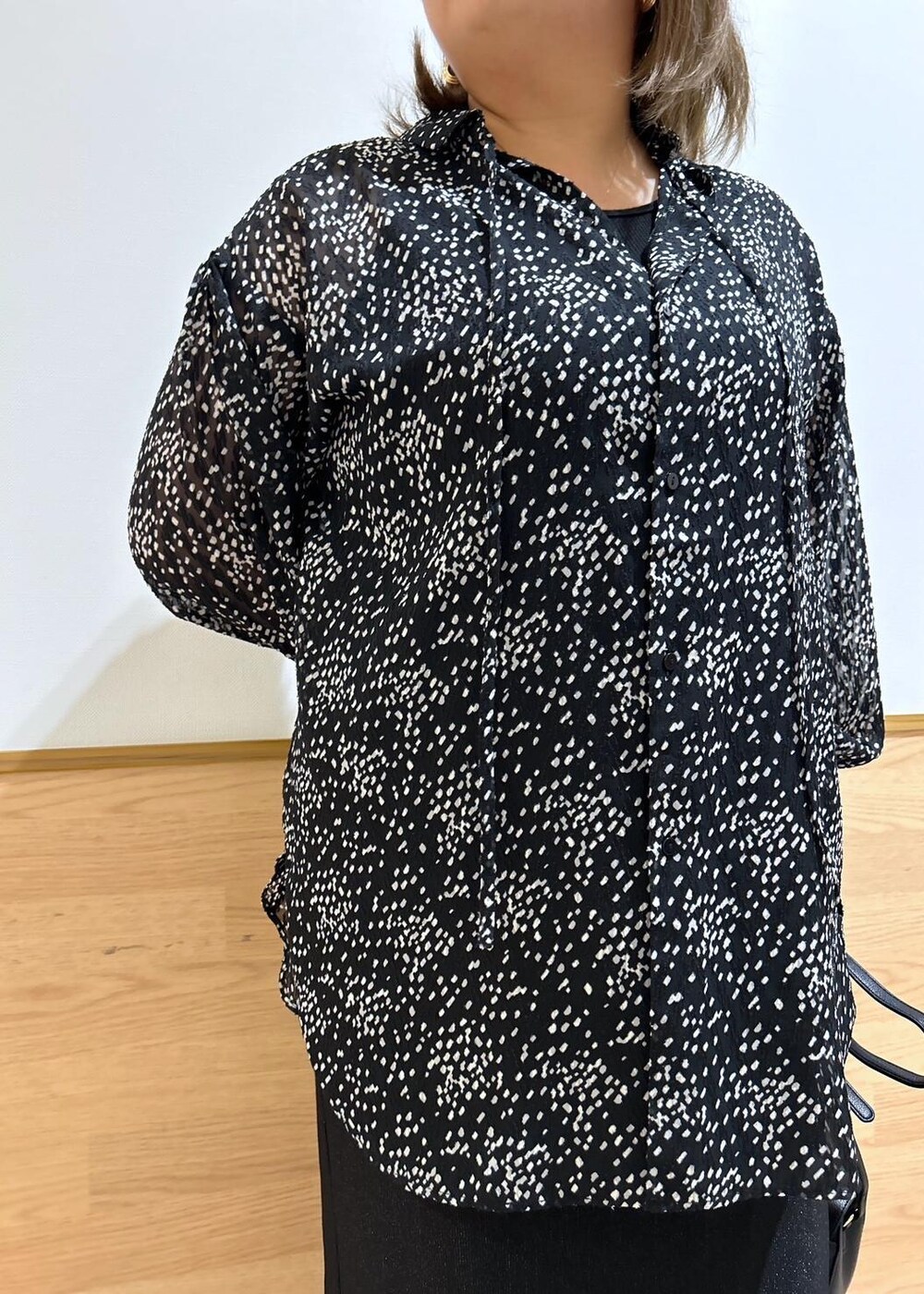 ブラック系のスカート、ブラック系のショルダーバッグ、ブラック系のシャツ/ブラウスを着用したレディースの秋コーディネートの4枚目の写真