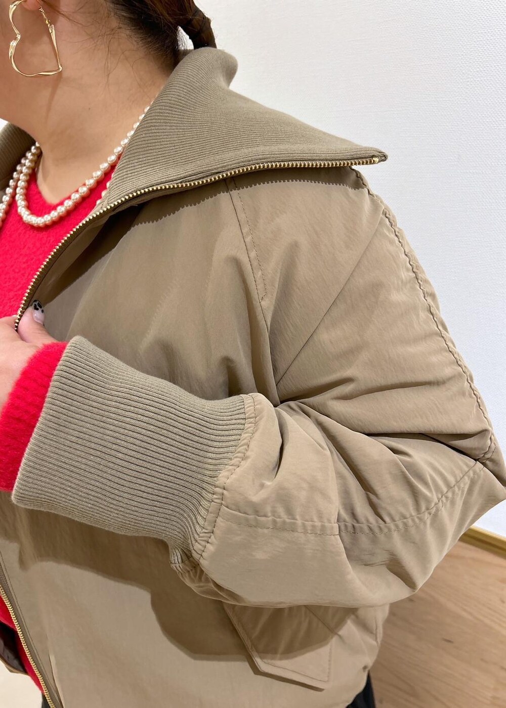 ブラック系のスカート、ブラック系のブーツ、シルバー系のショルダーバッグを着用したレディースの秋コーディネートの5枚目の写真