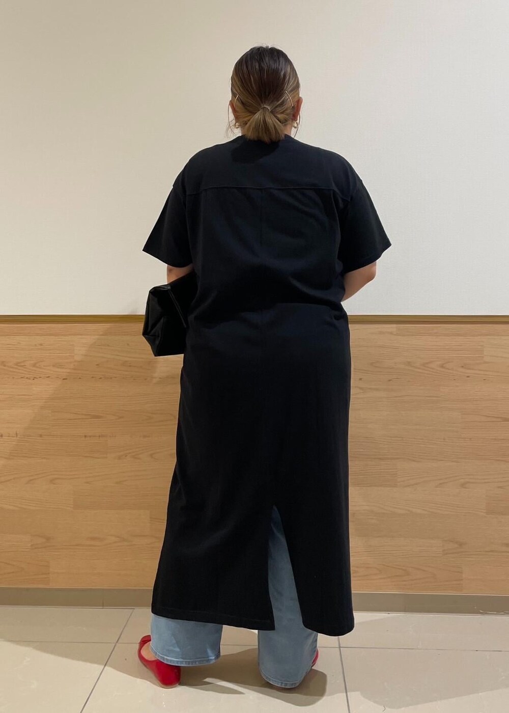 ブラック系のトートバッグ、ブルー系のデニムパンツ、レッド系のバレエシューズを着用したレディースの秋コーディネートの3枚目の写真