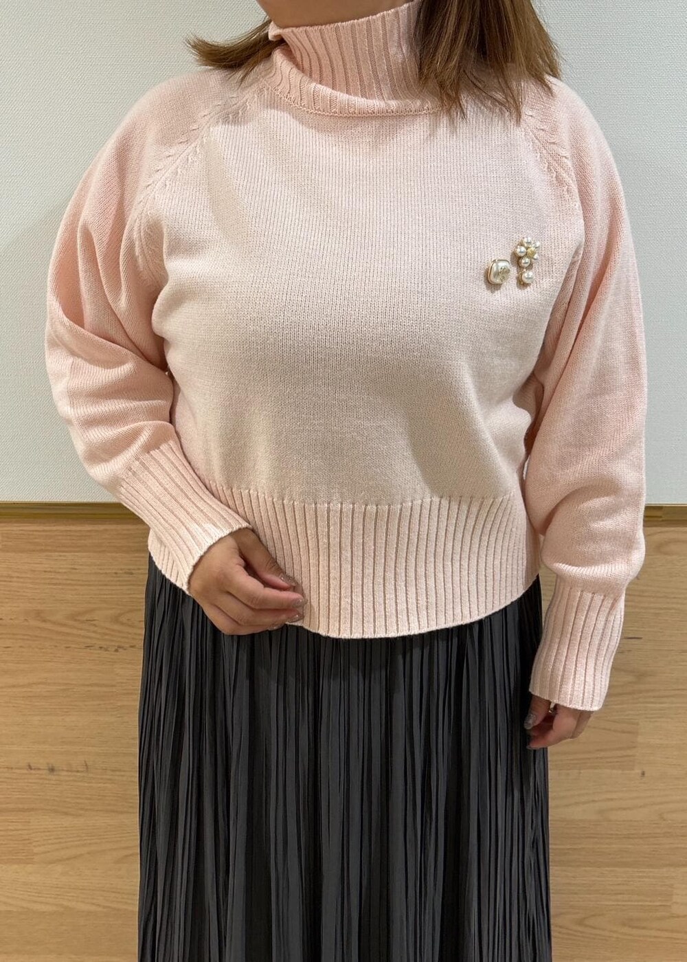 シルバー系のトートバッグ、グレー系のスカート、ピンク系のニット/セーターを着用したレディースの冬コーディネートの4枚目の写真