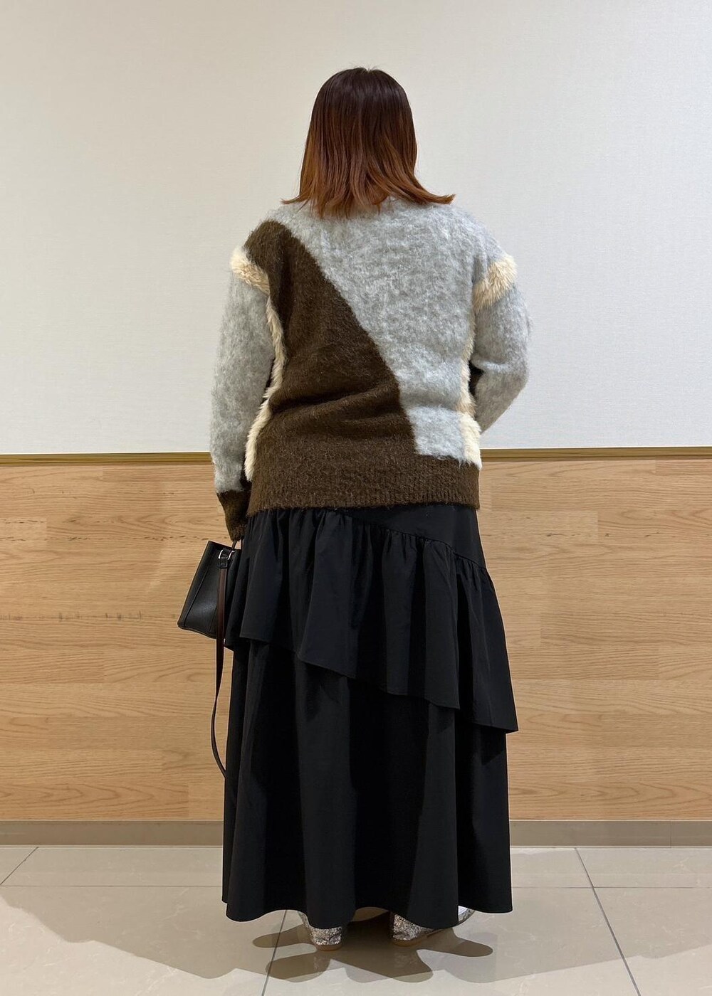 シルバー系のバレエシューズ、ブラック系のスカート、ブラウン系のニット/セーターを着用したレディースの秋コーディネートの3枚目の写真
