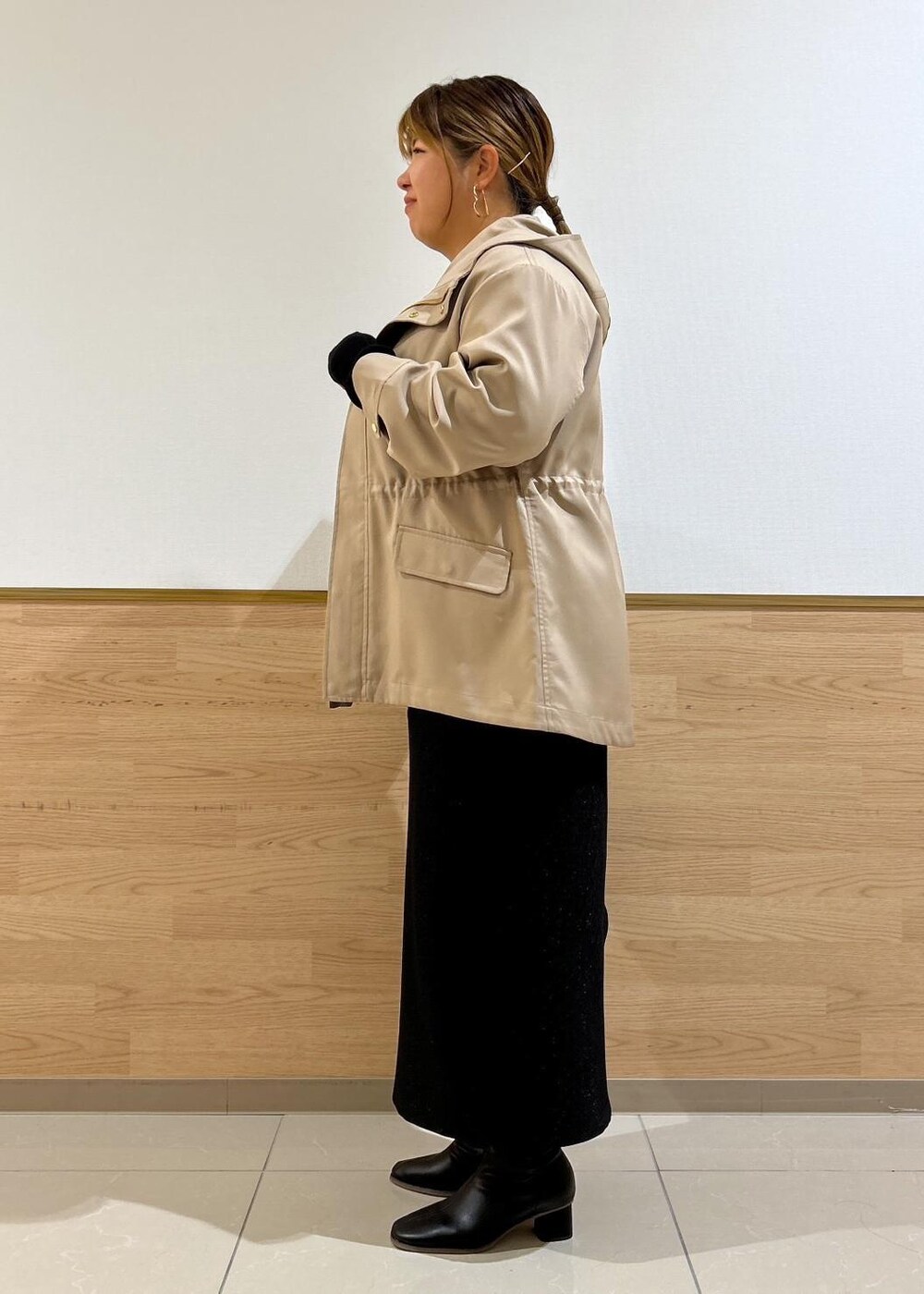 ブラック系のスカート、ブラウン系のマウンテンパーカー、ブラック系のブーツを着用したレディースの秋コーディネートの2枚目の写真