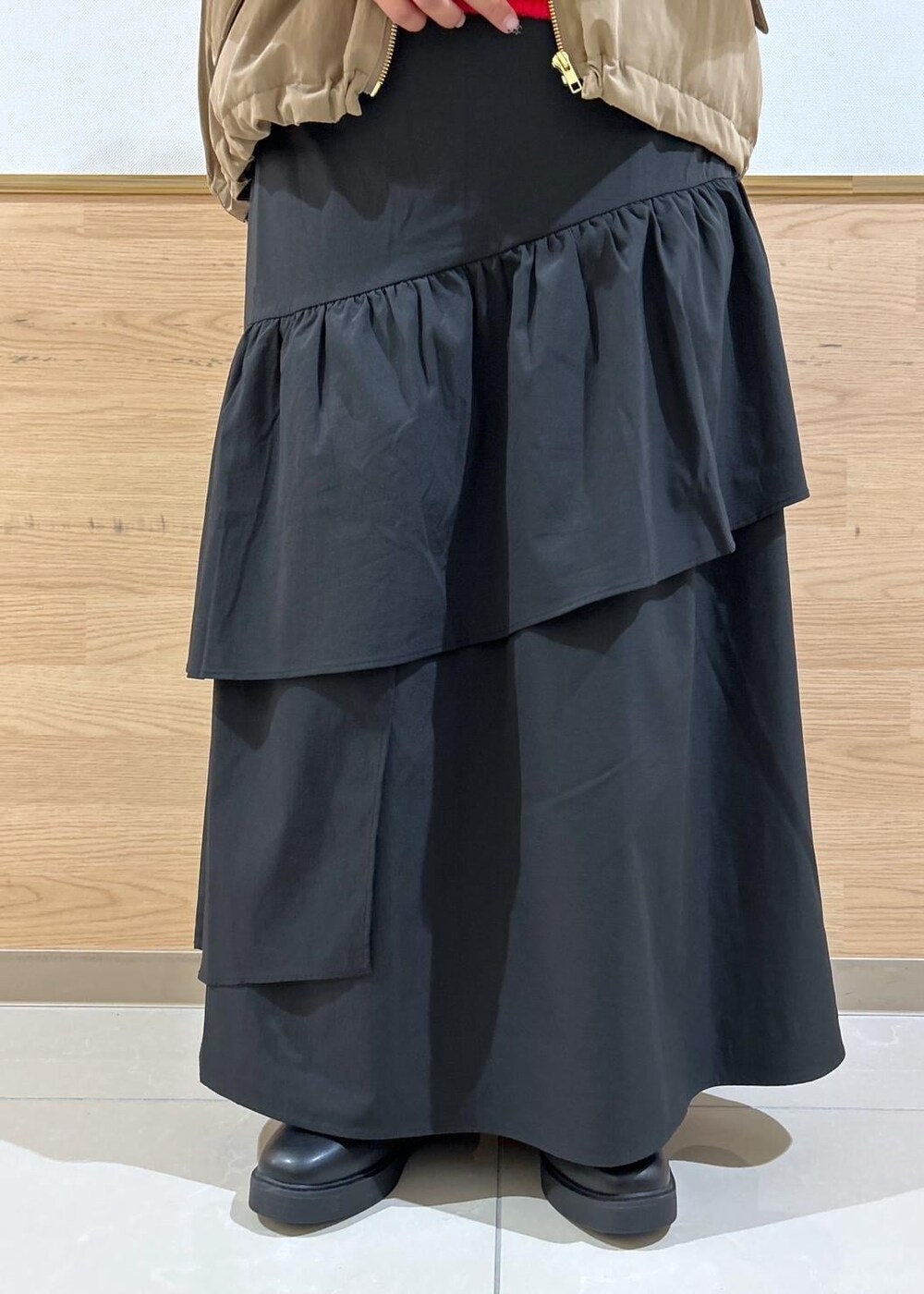 ブラック系のスカート、ブラック系のブーツ、シルバー系のショルダーバッグを着用したレディースの秋コーディネートの6枚目の写真